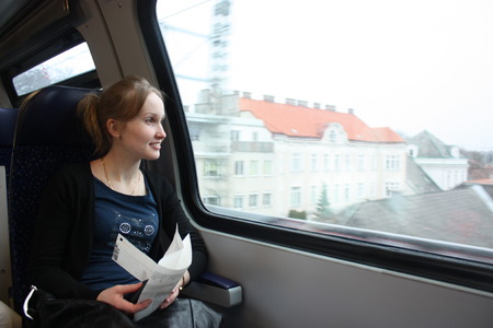 Young woman in the train looking through the window.