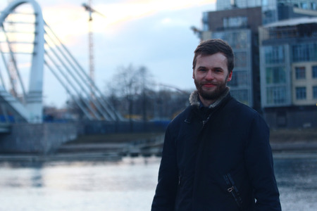 Portrait of young man in urban city. A construction of new building.
