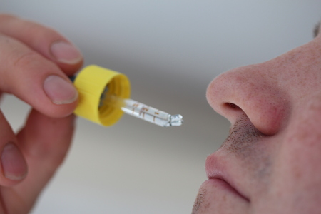 A man putting a nasal spray in nose.の写真素材