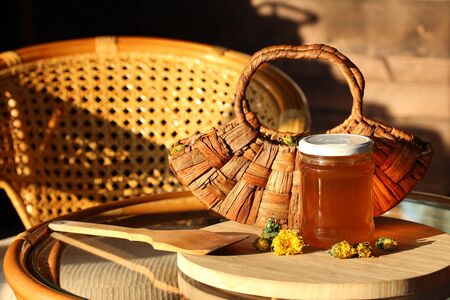 Dandelion Jelly and wooden basket of dandelion Flowers in the rays of the evening sun on the...