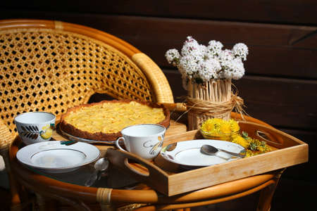 Tea party on the terrace. Apple Tart and vase of flowers on the table. Summer time.