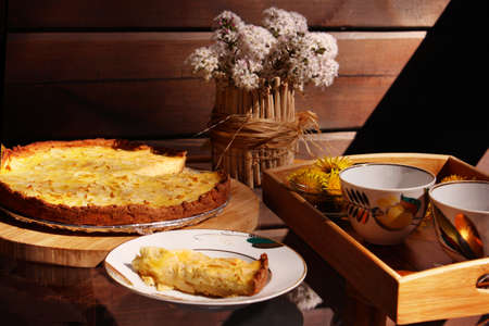A piece of apple pie on the plate. Tea party on sunny patio chatting. Summer time.