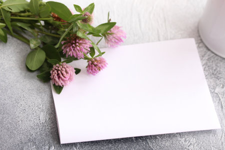 Blank paper notebook for drawing and clover bouquet. Romantic and cozy workplace.の写真素材