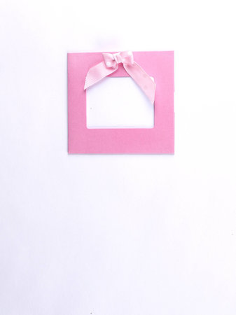 Square frame with pink bow and isolated on white backgroundの写真素材