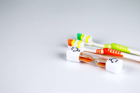 new tooth brush on a white background with sandglass time to changeの写真素材