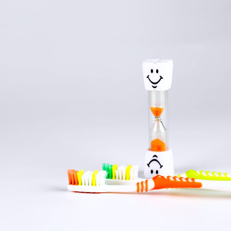 new tooth brush on a white background with sandglass time to change