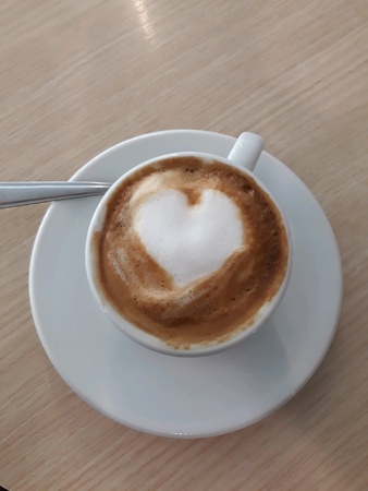A delicious cup of coffee with a drawing of a heart to express loveの素材