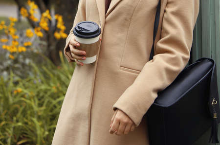 student pupil holding a cup of tea coffee drink season fall autumn school univesity lunch time beige...