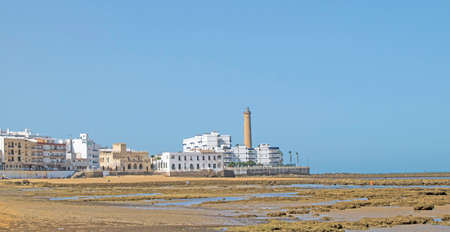 Fishing corrals at low tide on the beach with the Chipiona lighthouse in the background, Cadiz, Andalusia, Spain. Andalusian village traditionのeditorial素材