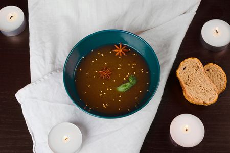Soup Broth with sesame seeds and aniseed bread and candlesの写真素材