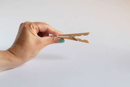 Hand holding a half open clothespins on white backgroundの写真素材