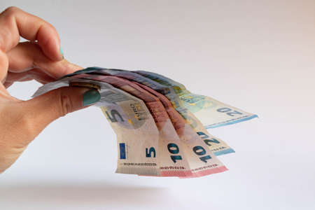 Hand holding some euro bills on white background