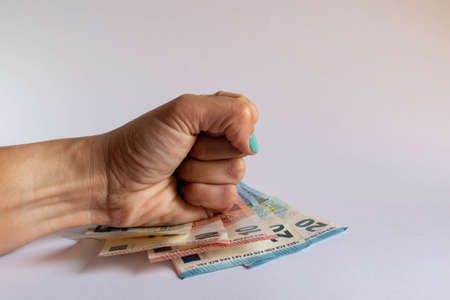 Energetically clenched fist on some euro bills on white backgroundの写真素材