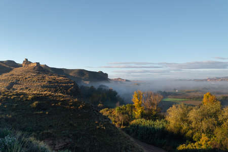 Ruins of the Arab castle in Maria de Huerva near Zaragoza early in the morning with mist in the valleyのeditorial素材
