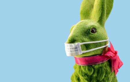 Easter bunny or rabbit with a medical mouth mask to prevent corona virus. Concept of cancellation of...