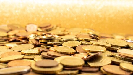 Many Euro coins on a glitter gold background