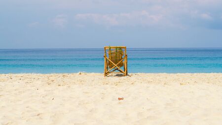 A bamboo chair in the middle of an empty beachの写真素材
