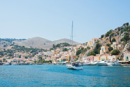 Yatch arriving at Symi harbor. View of the colorful village on a summer day. Dodecanese, Greeceの写真素材