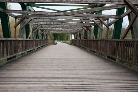 Crossing a wooden bridge with metal structureの写真素材
