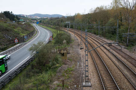 Railtracks and road arriving to Oviedo. Green scenario and city in the backgroundの写真素材