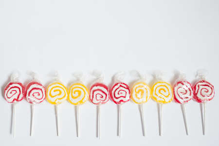 Pattern with red and yellow lollipops in a row. White backgroundの写真素材