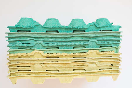 Texture. Pile of multicolored cardboard trays packaging for eggs. White backgroundの写真素材