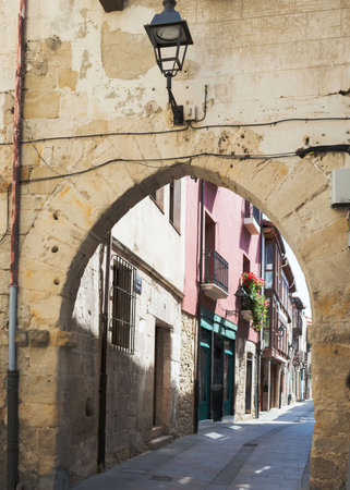 Beautiful old colorful street at Medina de Pomar. Stone arch and street lamp, Burgos, Merindades, Spain, Europeの写真素材