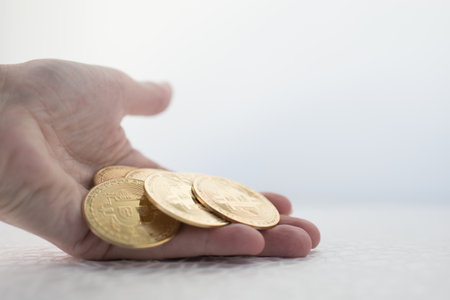 Beautiful hand of a woman with many bitcoins. White backgroundの写真素材