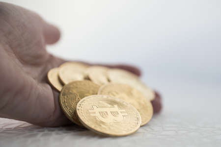 Woman hand showing golden coins. Crypto currency, bitcoin. White backgroundの写真素材