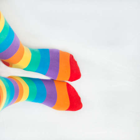 LGBTG + rights. Two left feet wearing rainbow flag socks. White backgroundの写真素材