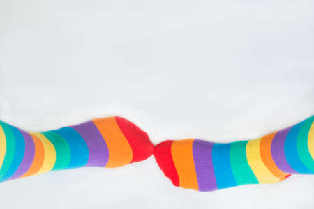 Visibility of LGBTQ + community. Two left feet wearing socks with rainbow flag. White background. Copy spaceの写真素材