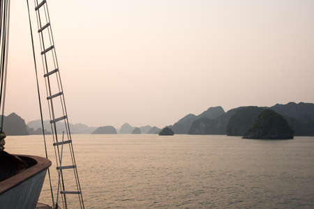 Beautiful sunset at Halong bay, Vietnam. Romantic scene from a sailboat, calm water, no people. Asia