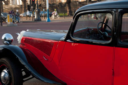 Beautiful red and black vintage car parked on a London street. Great Britainの写真素材