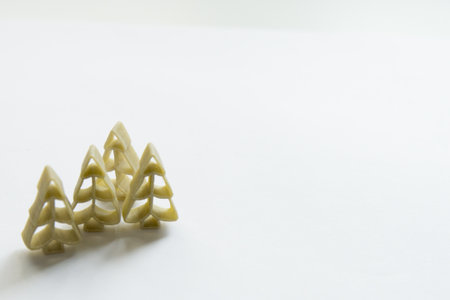 Winter pattern. Green tree shaped pasta. White background