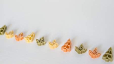 Raw pasta with assorted shapes and colors. White background