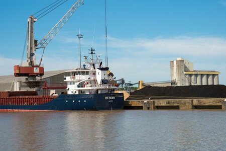 Loading coke in a nautical vessel at Bordeaux port. France