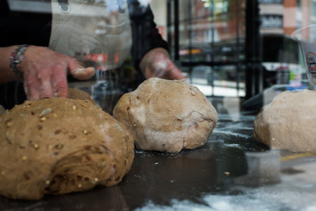 Unrecognizable woman preparing bread with seeds. Caucasian.