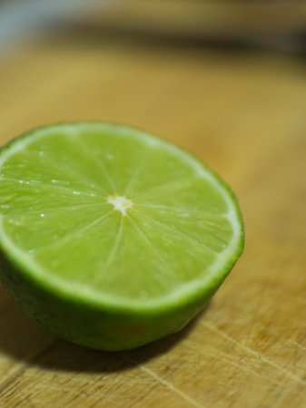 Close up of half lime on a wooden cutting table. No peopleの写真素材