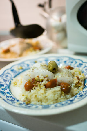 Dish with delicious rice with hake and cherry tomatoes. Kitchen