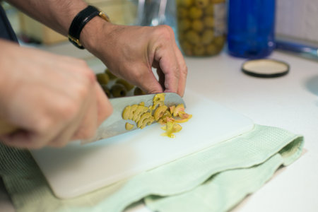 Man hands cutting olives. Japanese knife. Kitchenの写真素材