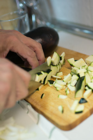 Human hands cutting zucchini into pieces. Interiorの写真素材