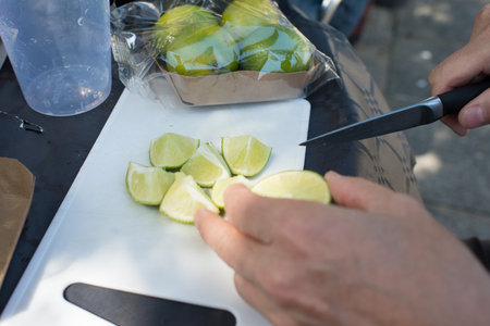 Caucasian hands cutting lime for mojito with a knifeの写真素材