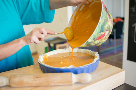 Unrecognizable woman cooking pumpkin cake. Madrid, Spain