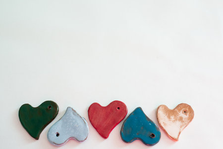 Diversity and love. Small ceramic heart shaped pieces. White backgroundの写真素材