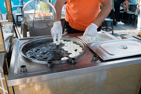 Unrecognizable vendor preparing fried calamari at Galata market, Istanbul. Street food is very common in Turkey.の写真素材