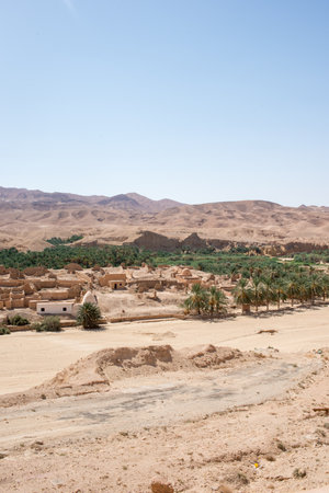Old Tamerza ruins and palm grove, in Tunisia. The village collapsed in 1969 following rains that lasted several days. The materials did not resist water infiltration and the villagers settled a few hundred meters further, the current Tamerza.の写真素材