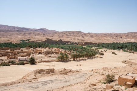 Ruins of old village of Tamerza or Tamaghza, abandoned in 1969 an palm forest around. The village collapsed following rains that lasted several days.の写真素材