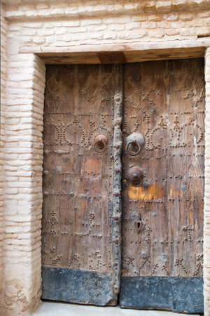 Beautiful traditional wooden door at Tozeur medina. Tunisia. Doors have three different door bells, that are used by men, women and children. That way, habitants can be aware of what kind of visit they are having before they open the door.の写真素材