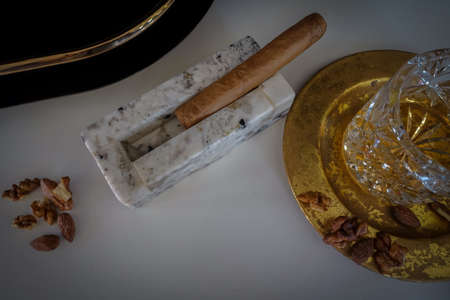 stone ashtray with cigars on a wooden tableの写真素材
