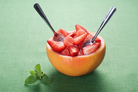 Fruit salad in hollowed-out grapefruit stuffed with strawberryの写真素材